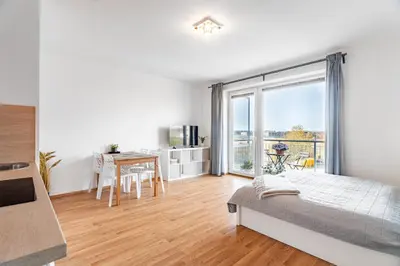 a bedroom with a bed and a large window at Airport Apartman Víšek in Chýně