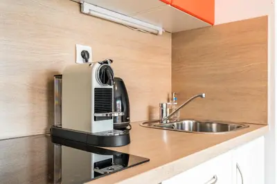a kitchen with a coffee maker and a sink at Airport Apartman Víšek in Chýně