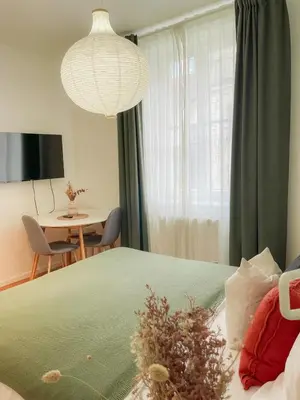 a bedroom with a bed and a table and a chandelier at True Relax Apartman 2 bedrooms Wenceslas square in Prague