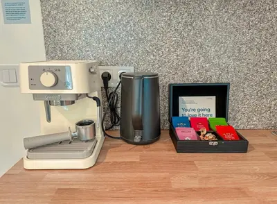 a counter with a coffee maker and a box of books at True Relax Apartman 2 bedrooms Wenceslas square in Prague