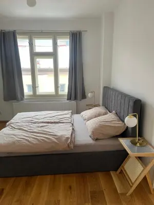 a bedroom with a bed and a window at myPoděbrady apartment in Poděbrady