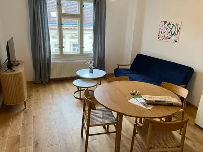 a living room with a table and a blue couch at myPoděbrady apartment in Poděbrady