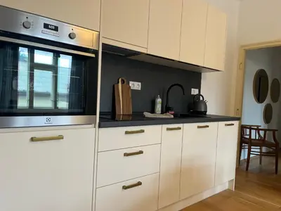 a kitchen with white cabinets and a microwave at myPoděbrady apartment in Poděbrady