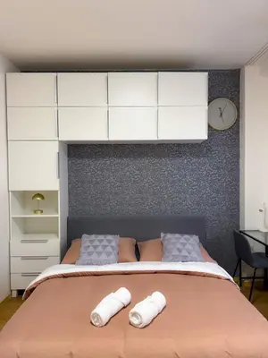 a bedroom with a large bed with white cabinets at Lotus Apartment Riverside stay in Prague