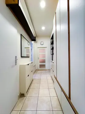 a hallway with white walls and a tile floor at Lotus Apartment Riverside stay in Prague
