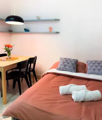 a bed in a room with a table and a dining room at Lotus Apartment Riverside stay in Prague