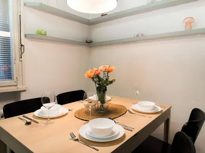 a dining room table with plates and a vase of flowers at Lotus Apartment Riverside stay in Prague