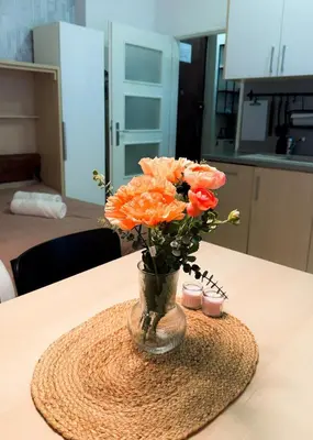 a vase filled with orange flowers on a table at Lotus Apartment Riverside stay in Prague