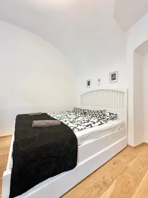 a white bedroom with a bed in a room at The Little Peaceful Retreat in Prague