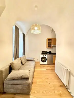 a living room with a couch and a kitchen at The Little Peaceful Retreat in Prague