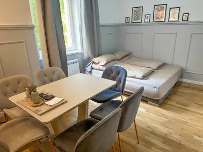 a room with a table and chairs and a bed at Elegant Apartment Near Main Station & Wenceslas Sq in Prague