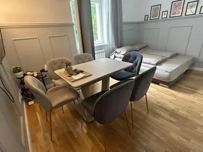 a living room with a table and chairs and a bed at Elegant Apartment Near Main Station & Wenceslas Sq in Prague