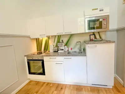a kitchen with white cabinets and a sink at Elegant Apartment Near Main Station & Wenceslas Sq in Prague