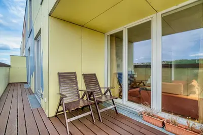 two chairs sitting on the balcony of a house at LOcelot Premium 2 floor Apartment near O2 Arena in Prague
