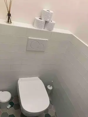 a bathroom with a toilet and two towels on a shelf at Live like a local family in Letna in Prague