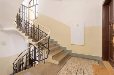 a staircase in a building with a white door at Live like a local family in Letna in Prague