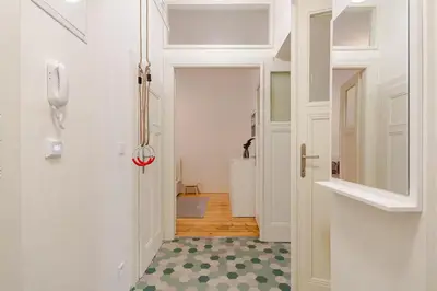 a hallway with a white door with a green and white floor at Live like a local family in Letna in Prague