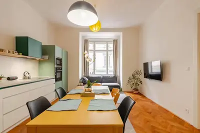 a kitchen and a dining room with a table and chairs at Live like a local family in Letna in Prague