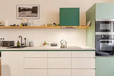 a kitchen with white appliances and green cabinets at Live like a local family in Letna in Prague