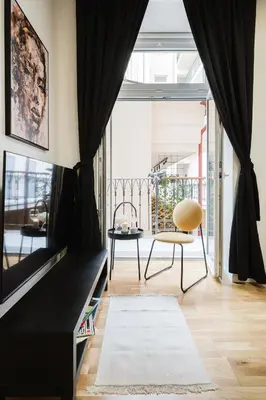 a living room with a black couch and a chair at Prague Days - One-bedroom Apartment with Netflix and High Speed WiFi in Karlín in Prague