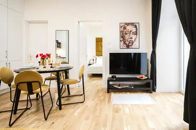 a living room with a table with chairs and a television at Prague Days - One-bedroom Apartment with Netflix and High Speed WiFi in Karlín in Prague