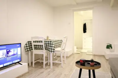 a living room with a table and chairs and a television at Chill Vibes Netflix, PS5 & Free Parking! in Prague