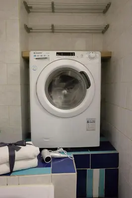 a washing machine sitting on a shelf in a bathroom at Chill Vibes Netflix, PS5 & Free Parking! in Prague