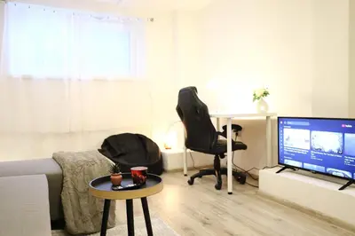 a living room with a television and a desk and chairs at Chill Vibes Netflix, PS5 & Free Parking! in Prague