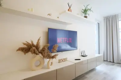 a living room with a television on a white cabinet at Leo Cozy Flat Big Balcony Prague in Prague