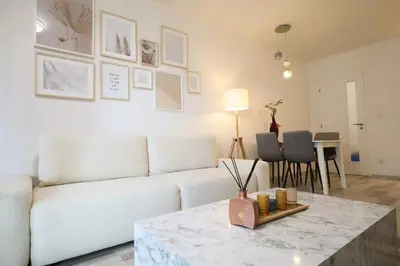 a living room with a white couch and a table at Leo Cozy Flat Big Balcony Prague in Prague