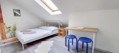 a bedroom with a bed and two blue stools at Soukromý pokoj Milada in Prague