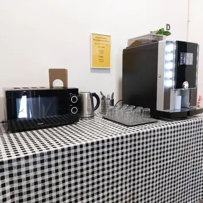 a black and white checkered counter top with a microwave and coffee maker at Soukromý pokoj Milada in Prague