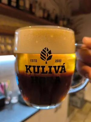a person is holding a cup of coffee at Pivovar Kulivá Hora in Třebotov