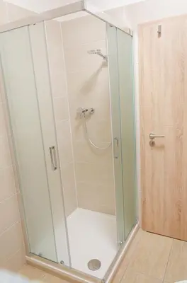 a shower with a glass enclosure in a bathroom at Pivovar Kulivá Hora in Třebotov