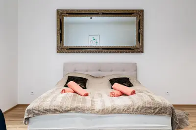 a person laying on a bed under a mirror at Modern Deluxe Suite in Prague