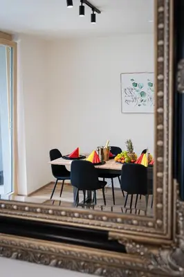 a dining room mirror with a table and chairs at Modern Deluxe Suite in Prague
