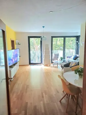 a living room with a table and a tv at 10min to the center Modern Flat in Prague