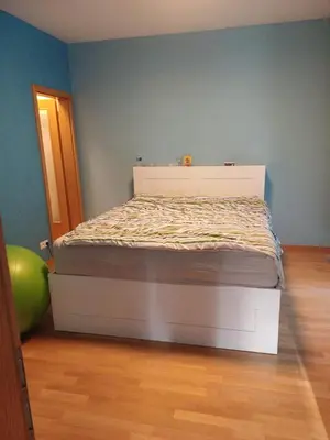 a balcony with a wooden chair and a table at 10min to the center Modern Flat in Prague