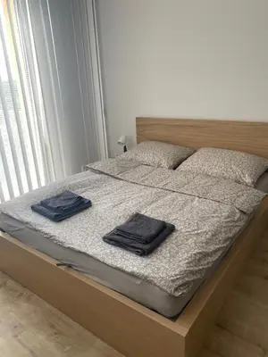a bedroom with a bed with two towels on it at Apartmán ELEN, Sky View in Prague