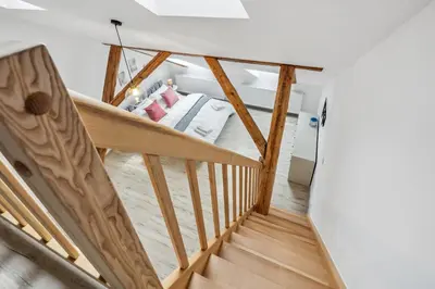 a staircase leading to a bedroom with a bed at Spacious two-storey apartment with a terrace in the city center in Benešov
