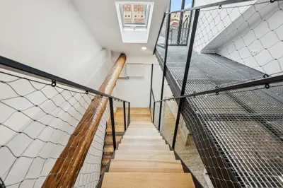 a staircase in a building with a metal railing at Spacious two-storey apartment with a terrace in the city center in Benešov