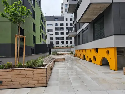 a courtyard in a building with benches and plants at Sun Prague - Stodůlky in Prague