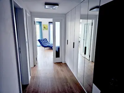 a living room with a blue couch and a mirror at Sun Prague - Stodůlky in Prague