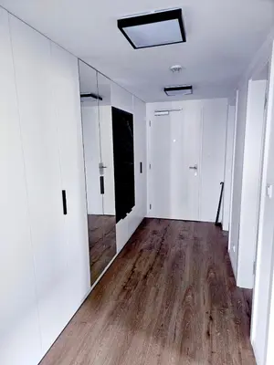 an empty room with white walls and wood floors at Sun Prague - Stodůlky in Prague