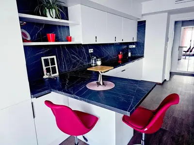 a kitchen with red chairs and a blue counter top at Sun Prague - Stodůlky in Prague