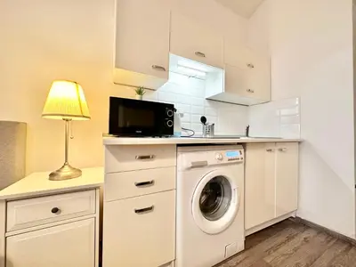 a kitchen with a washing machine and a lamp at The Little Peaceful Retreat Near Center in Prague
