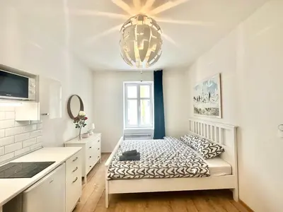 a room with a bed in a kitchen with a chandelier at The Little Peaceful Retreat Near Center in Prague