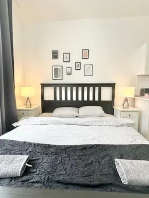 a bedroom with a large bed with two lamps at The Little Peaceful Retreat Near Center in Prague