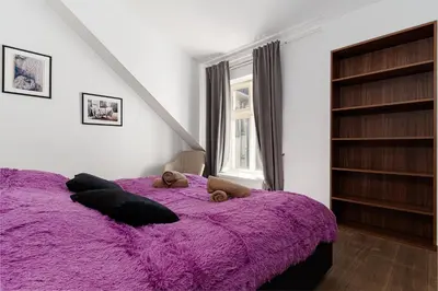 a purple bed with two teddy bears on it at Deluxe Rabbit Suite in Prague