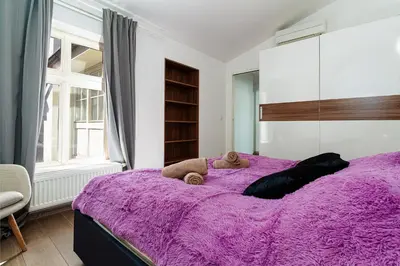 a bedroom with a purple bed with a purple blanket at Deluxe Rabbit Suite in Prague
